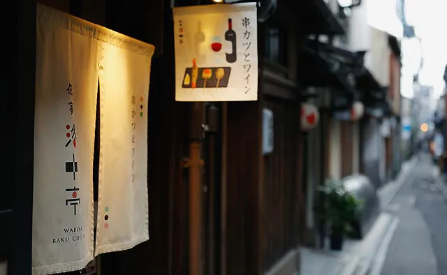 侘家洛中亭：鴨川沿いの花街・先斗町にあるお店。可愛らしいイラストが描かれた看板と、ロゴがあしらわれた暖簾が目印です