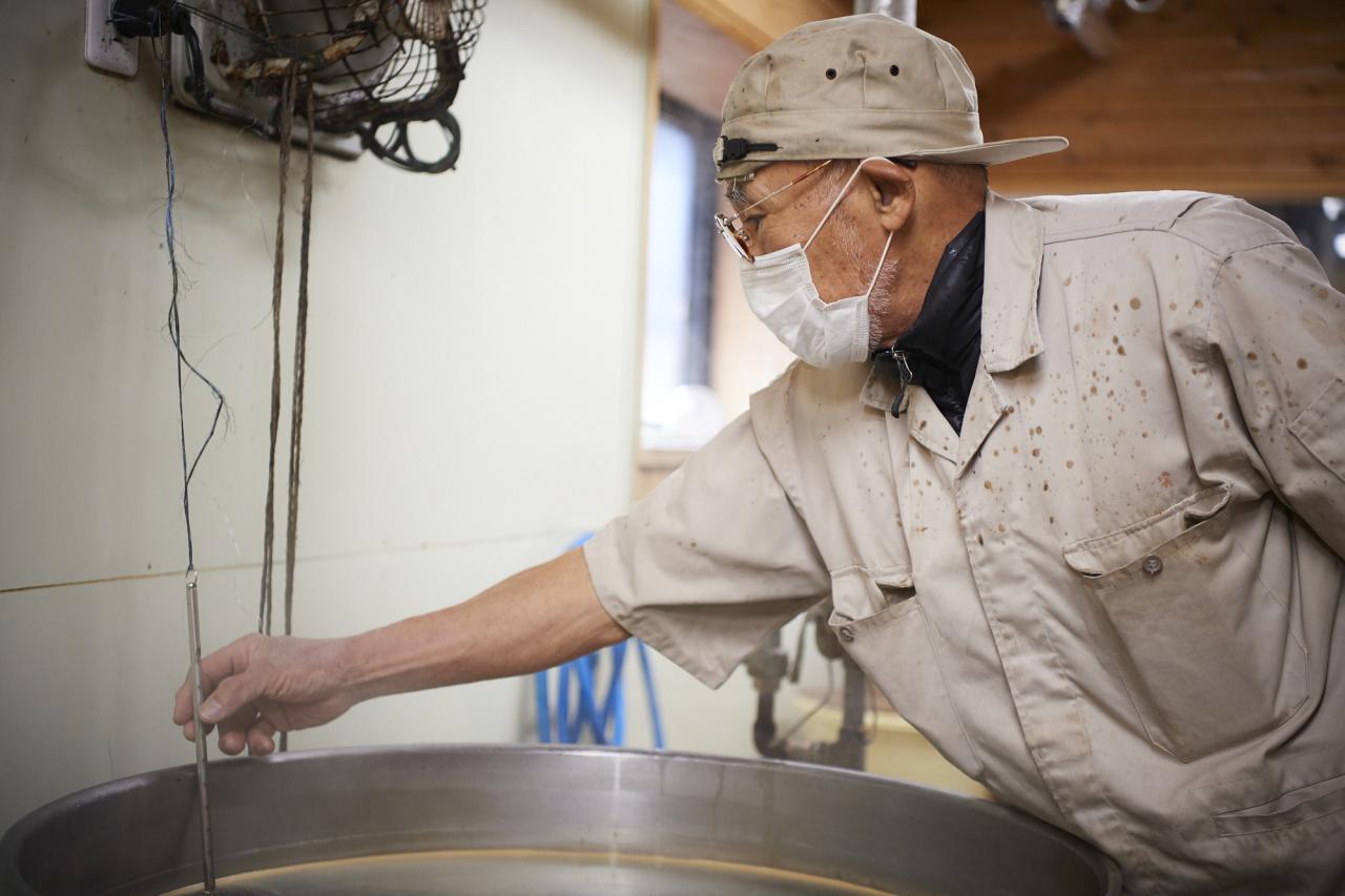 火入れ作業を行う〈明治屋醤油〉社長 5代目 野末一宏さん。